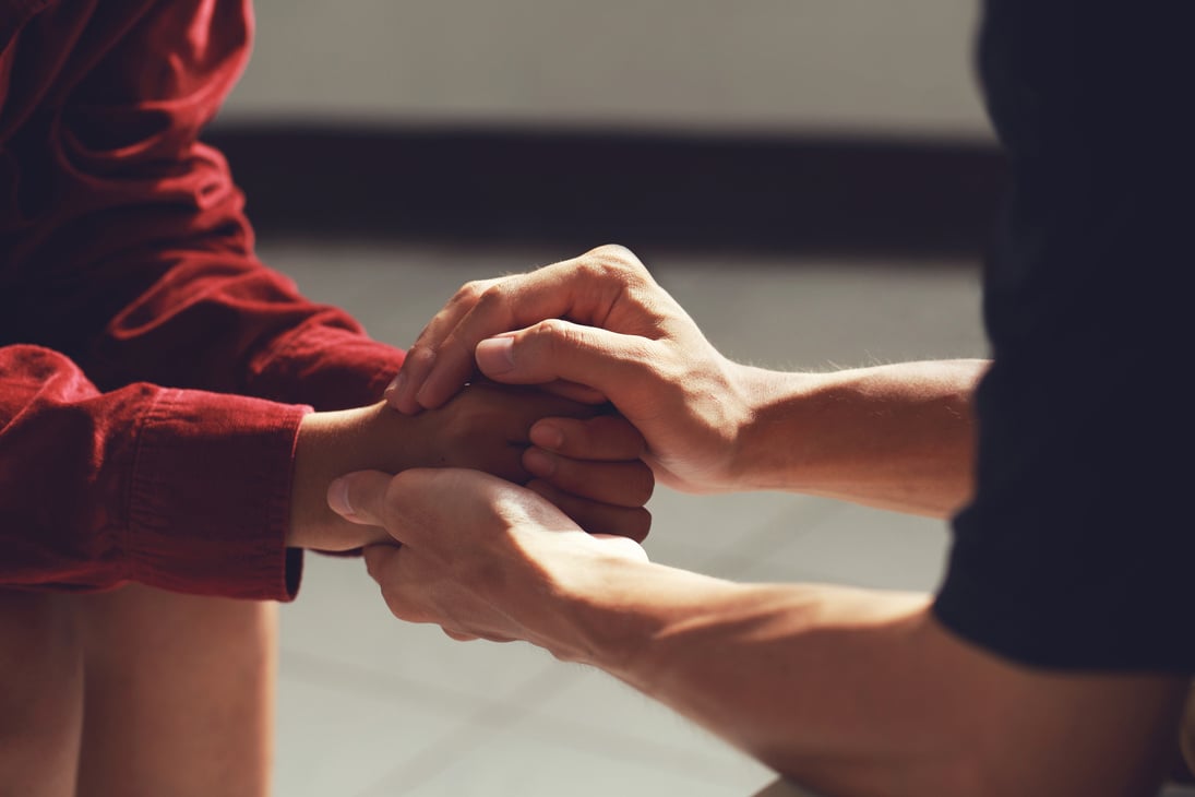 Man Holding a Woman's Hands for Comfort